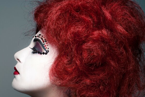 Fille aux cheveux rouges avec strass sur les sourcils