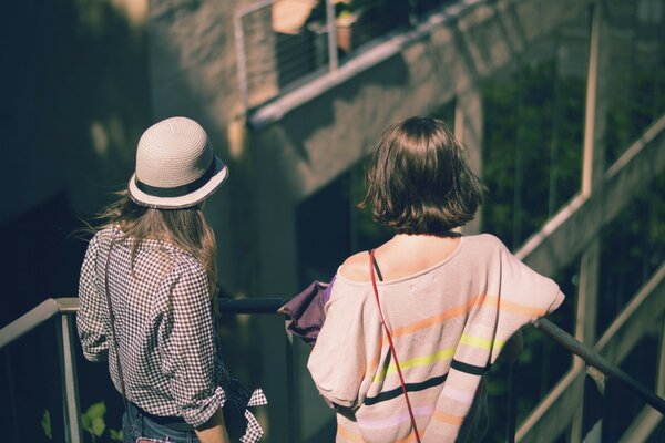 Two girls are standing on the stairs