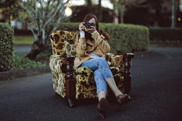 Photographer girl in a chair in the middle of the park