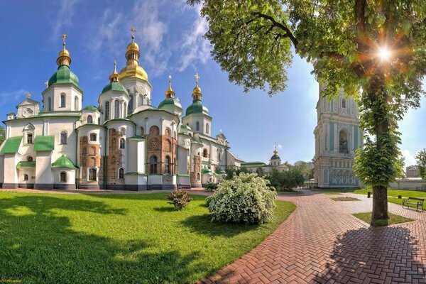 White temple with golden domes in summer