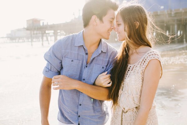 A girl with a guy on the beach on a sunny day