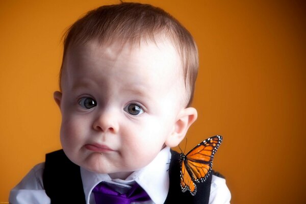 Mignon bébé en costume avec papillon