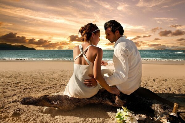 Amantes en la playa en medio de la puesta de sol