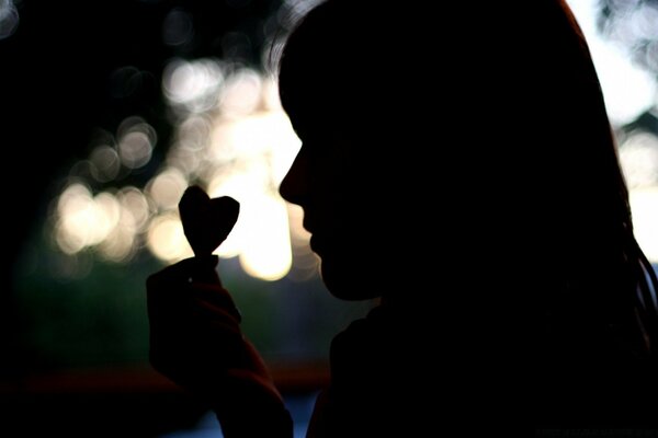 Femme mystérieuse avec un cœur dans les mains