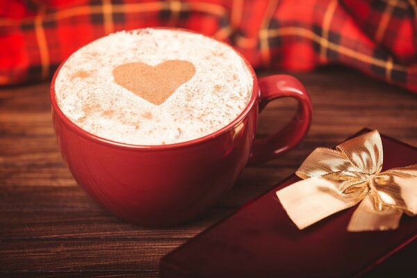 Coffee with a heart and a gift nearby