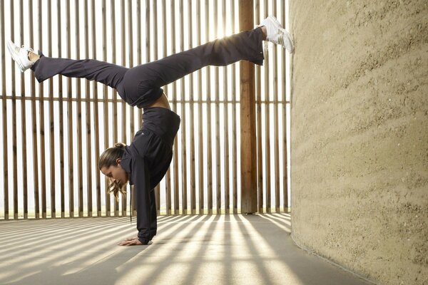 The girl does the splits in a handstand