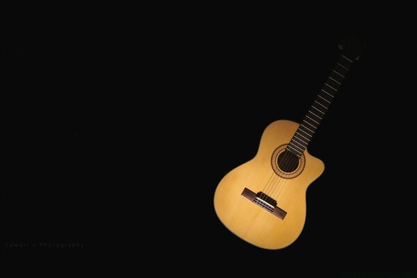 Guitarra musical de madera sobre fondo negro