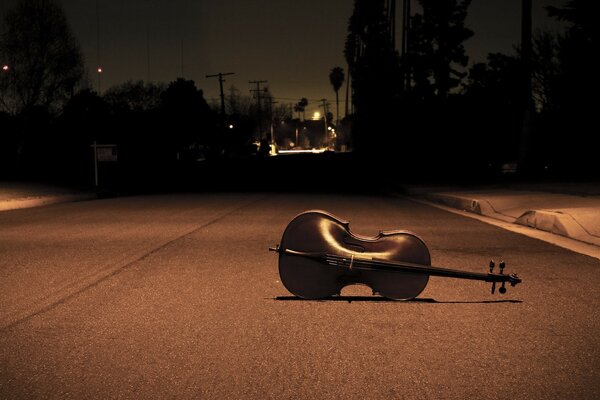 Violín en el camino bajo la luz de la linterna