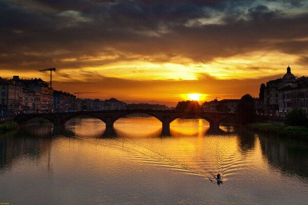 Reflection of the bridge in the sunset waters of the river