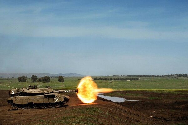 Der Moment des Geschosses des Tanks vor dem Hintergrund der Natur