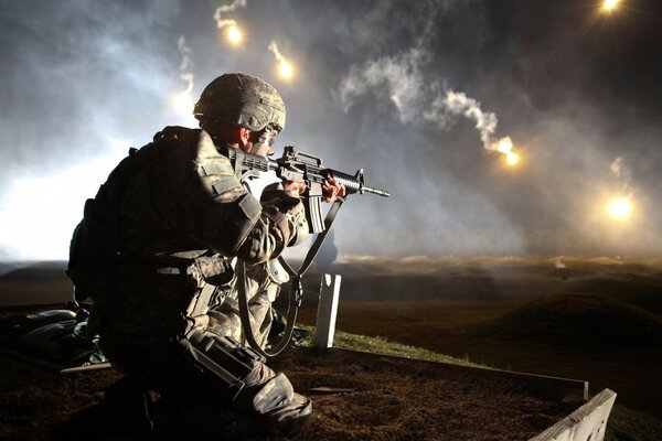 A soldier with a machine gun is ready for shooting