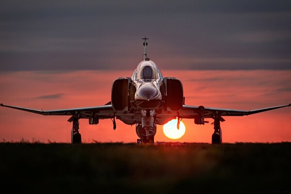 Stehendes Militärflugzeug bei Sonnenuntergang