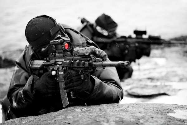 The sniper looks into the optical sight of the machine gun