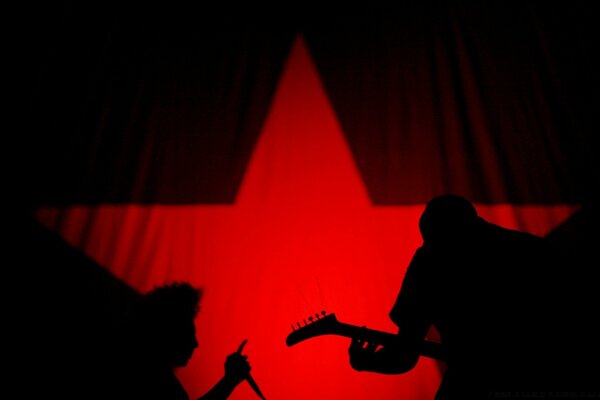 A duo of musicians on the background of a red star