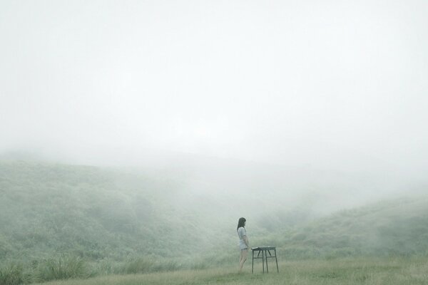 Fille dans le brouillard sur la montagne en été