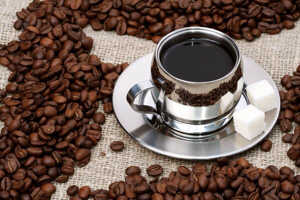 Coffee with sugar among the scattered coffee beans