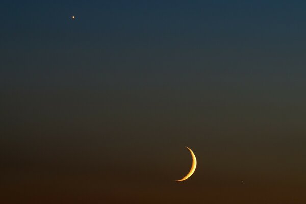 A moon and a star at night in the sky