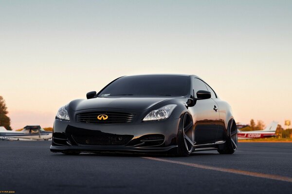 Black sports car on the road at sunset