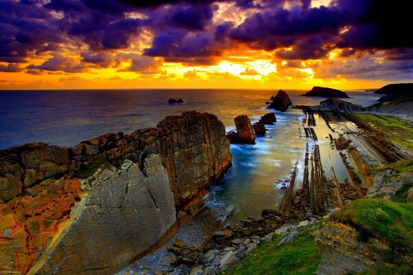 Strikingly bright colors of the landscape with rocks and the sea at sunset