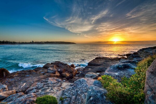 Puesta de sol en una playa inhóspita y rocosa