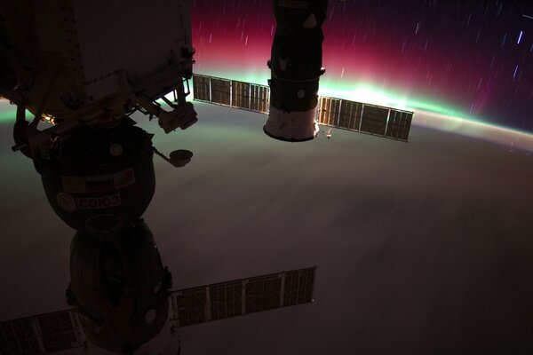 Foto de una nave espacial desde el espacio en el fondo de la Aurora boreal