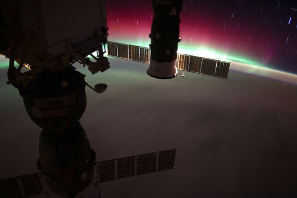 Kuzey ışıklarının arka planına karşı uzaydan bir uzay gemisinin fotoğrafı