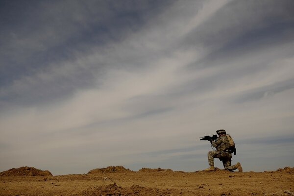 Un homme d infanterie se dresse sur un terrain sablonneux