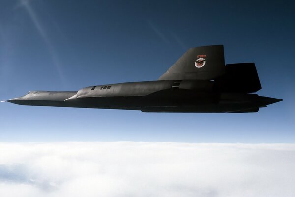 Avion militaire de couleur sombre sur fond de ciel