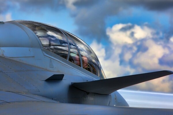 Fuselagem de um caça militar em meio a nuvens