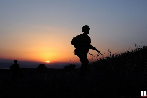 Infantería en marcha en medio de la puesta del sol