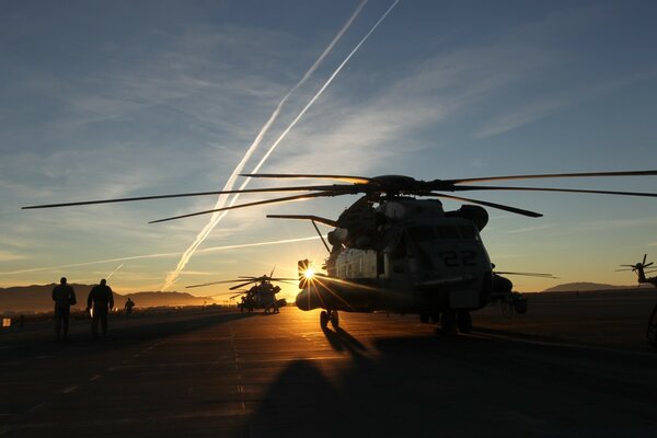 Hubschrauber fliegen bei Sonnenuntergang ab