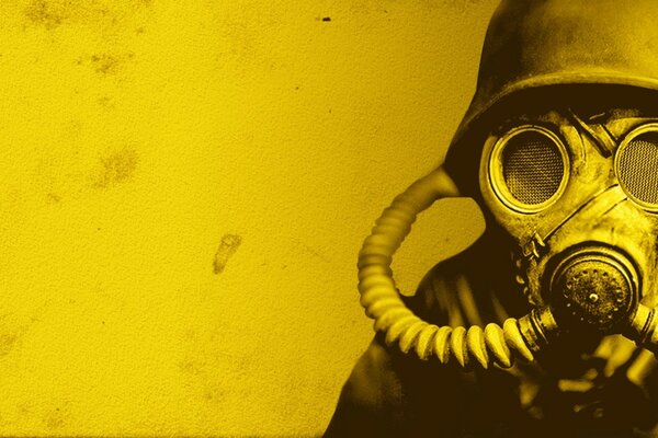 A man in a gas mask standing on a yellow fountain