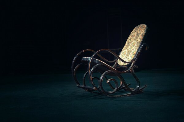 A lonely rocking chair on a black background