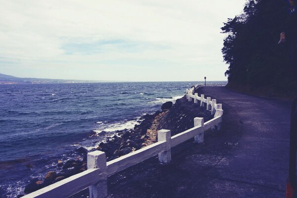 The highway along the seashore. A winding highway. Rocky shore