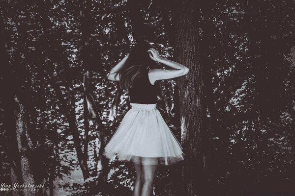 A girl poses at a tree