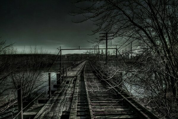 Landscape of a railway with a wooden bridge in the twilight