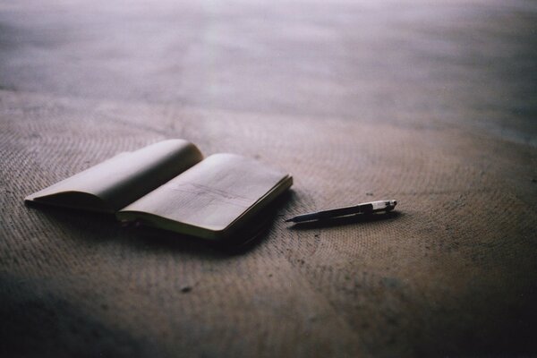 Laptop and book with pen on the beach