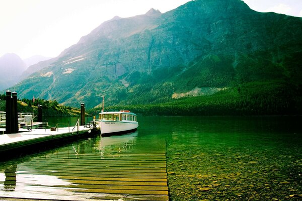 A river with a boat. Mountains and the sun