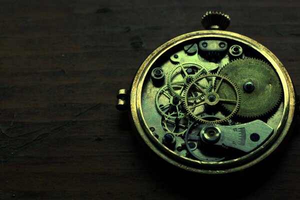 Gears of a clockwork mechanism on a dark background Dere