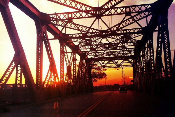 Iron bridge on the background of a red sunset