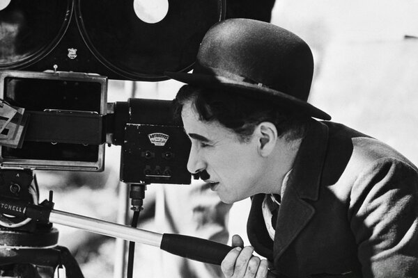 Charlie Chaplin in bombetta guarda le telecamere del cinema