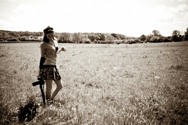 An adult girl in a mini skirt in a field in a black and white photo