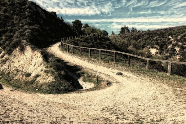 Photo of a mountain hiking trail with a fence