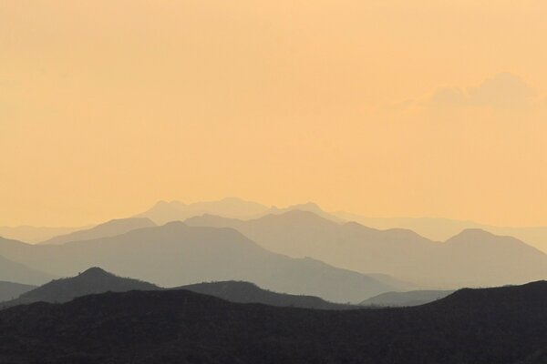 Foto de las montañas en la niebla en el fondo de la puesta de sol