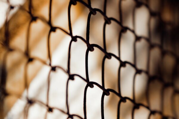 Metal mesh fence through the sun