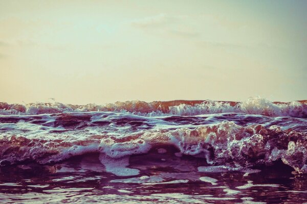 Puesta de sol y olas del océano en la espuma