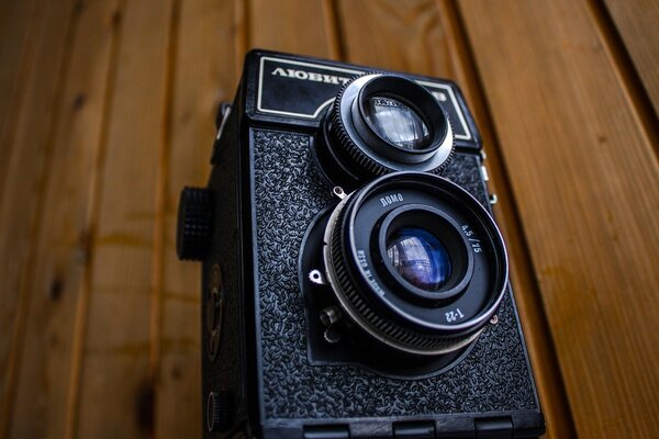 Camera lens on a wooden surface