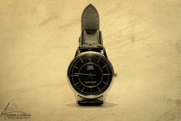 Watch with black dial and strap on a light background