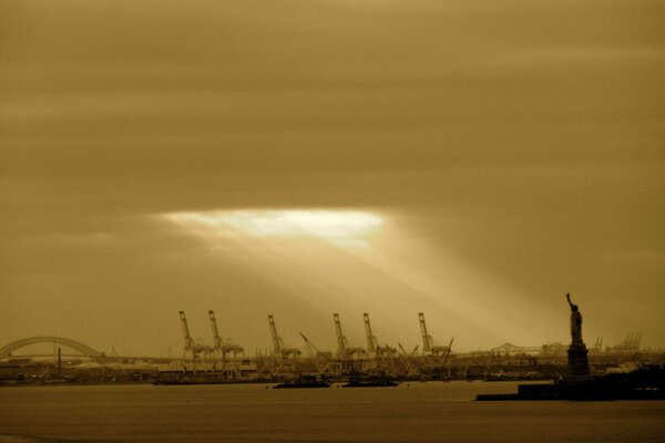 The sun s rays break through the clouds and illuminate the Statue of Liberty