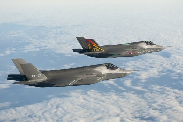 Two fighter jets fly in a pair in the sky